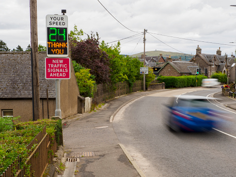 Car passing a Radar-Operated Speed Warning Sign