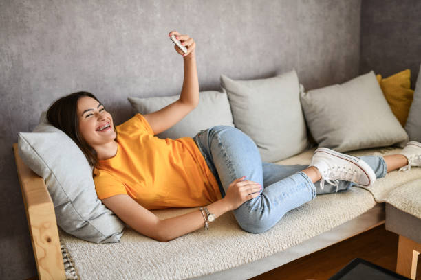 istock Female Giving Toothy Grin While Taking Smartphone Selfie 1415217935
