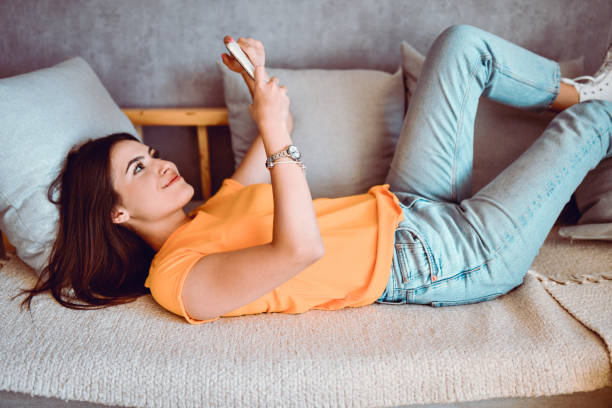 istock Cute Female Exploring The Net On Smartphone 1415218700
