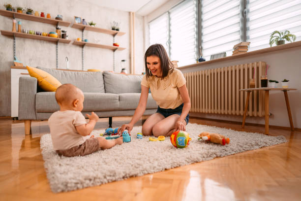 istock Young Mother Playing With Her Baby On The Floor 1415222436
