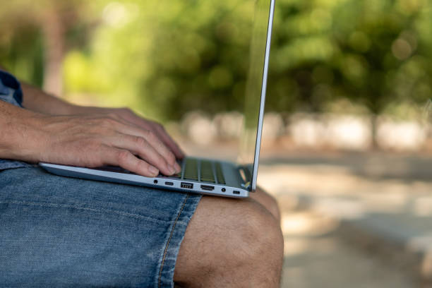istock Male hands on laptop, outside a park 1415222487