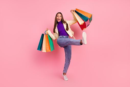 Full size photo of success brunette young lady hold bags yell wear trend cloth boots isolated on pink color background.