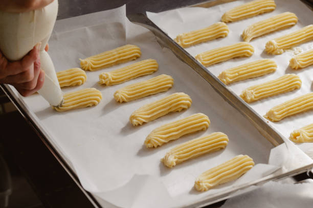 istock use of a pouch to form baking eclairs, bakery concept 1415222894