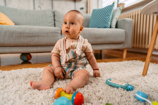 istock Newborn Baby Boy Playing On The Floor 1415223247