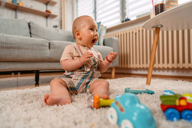 istock Newborn Baby Boy Playing On The Floor 1415223839