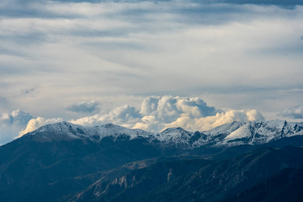istock Clouds Brew Over Snow Capped Mountains in Colorado 1415228567