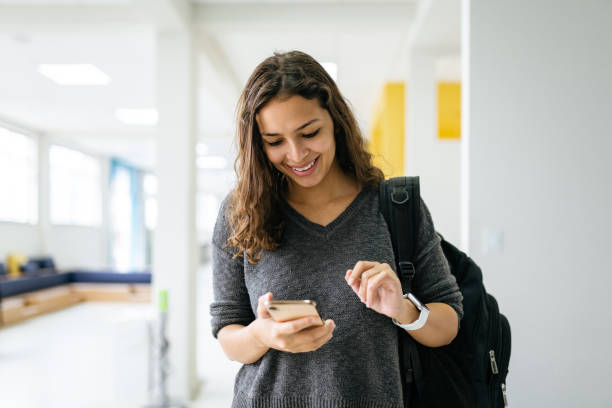 Young woman using smartphone at university Young woman using smartphone at university education student mobile phone university stock pictures, royalty-free photos & images