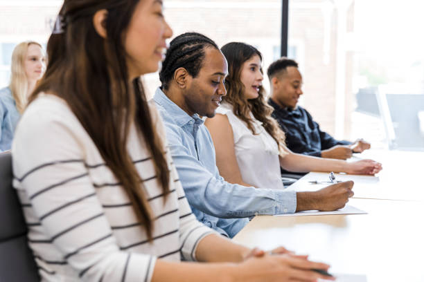 istock Diverse students listen as young woman interacts with unseen professor 1415231327