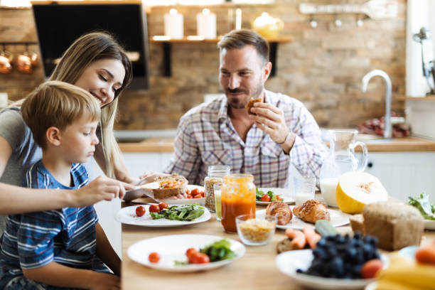 istock Young mother  feeding her son  in dining room 1415231404