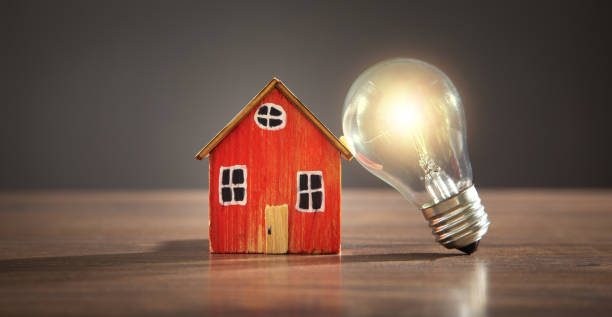 istock House model and light bulb on the wooden table. 1415233067