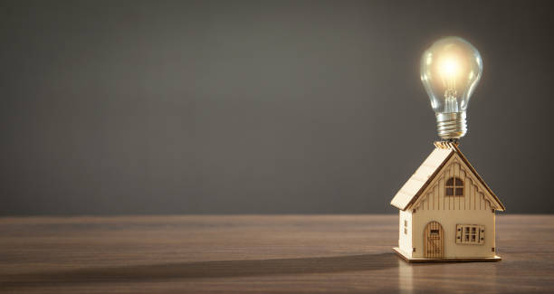 istock House model and light bulb on the wooden table. 1415233075