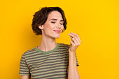 Closeup photo of young smiling sniff girl showing cool aroma like buy parfume isolated on yellow color background