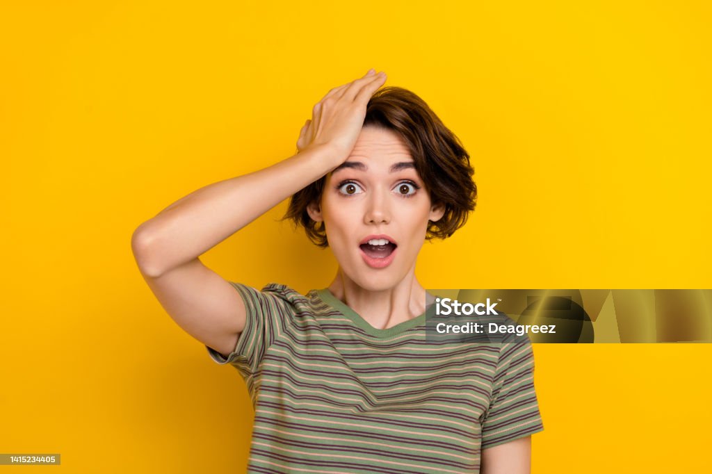 Closeup photo of young funny grimace girl touching head forgot turn off computer home isolated on yelow color background Closeup photo of young funny grimace girl touching head forgot turn off computer home isolated on yelow color background. Reminder Stock Photo
