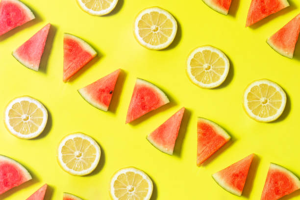 istock Creative pattern with watermelon and lemon slices on sunny yellow background. Colorful summer concept. Minimal fresh fruit idea. 1415236823