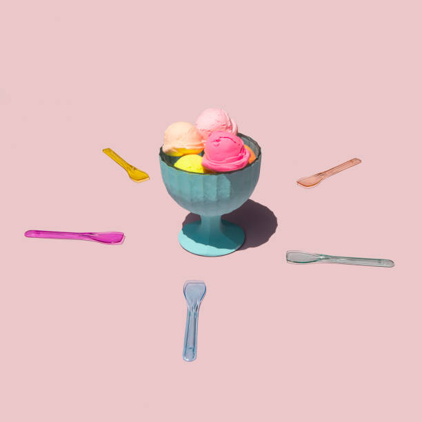 Pastel light ice cream balls in cup on light pastel pink background. Creative food concept. Minimalistic sweets composition. Sunny summer day idea.
