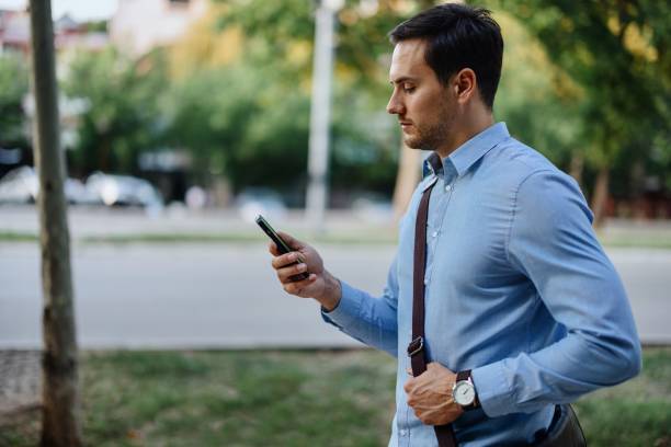 istock Businessman in downtown, using mobile phone 1415237349