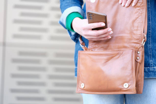 istock Woman hand opens a bag and holds smartphone 1415237374
