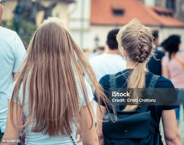 Back View With Two Blonde Girls Walking On The Streets Of Prague Stock