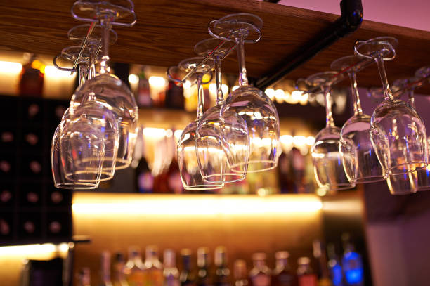istock Close up wine glass on rack above blurred bar background 1415239119