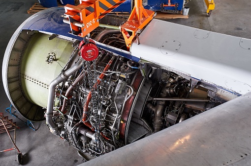 repairing the turbine engine of a passenger jet at a hangar. Open airplane motor
