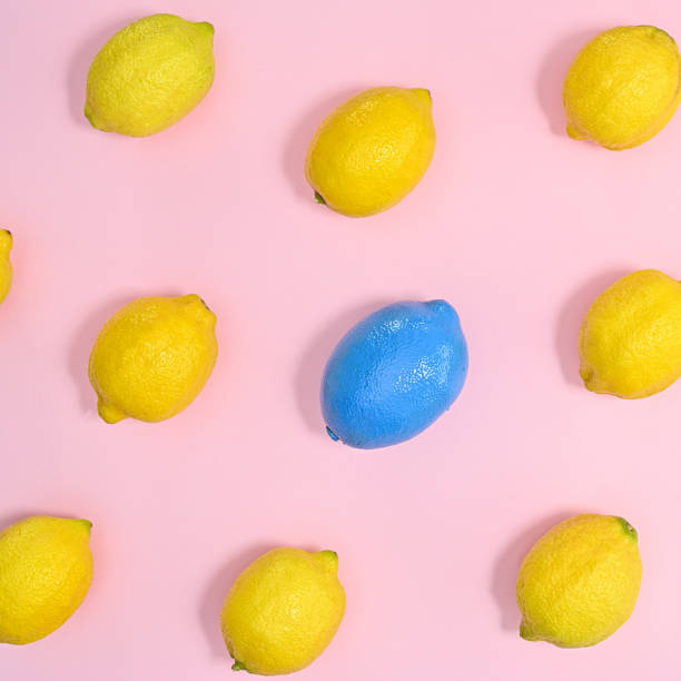 istock Creative pattern with yellow lemons and one blue on pastel pink background. Flat lay 1415239926