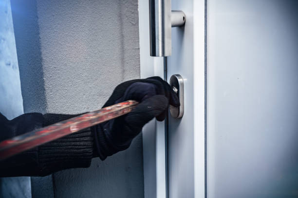 masked burglars breaking and entering into a victim's home stock photo