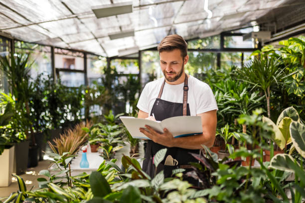 istock Florist checking potted plants in flower shop 1415240070