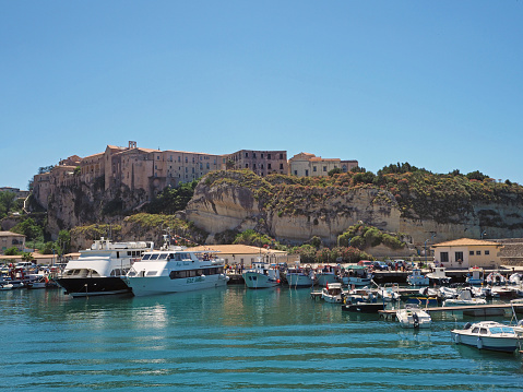 view on old city Tropea form marina port with ship yachts and turquoise sea and blue sky