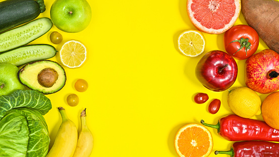 Yellow copy space background with green and red fruits and vegetables. Healthy lifestyle and dieting concept. Flat lay