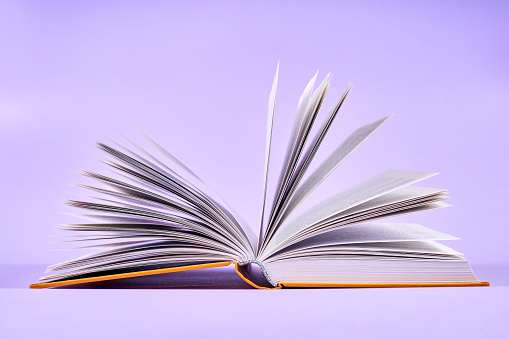 An open book on purple background