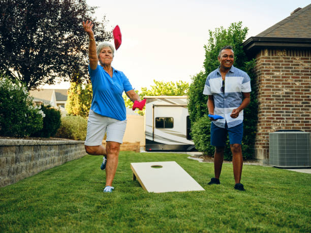 コーンホールビーンバッグトスゲームをプレイバックヤードパーティー - cornhole leisure games outdoors color image ストックフォトと画像