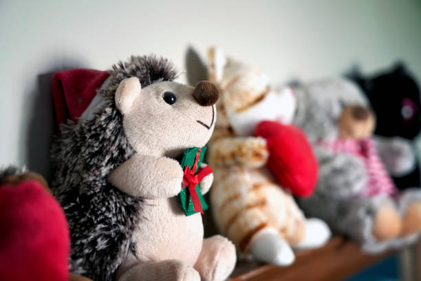 A picture of many adorable plush toys lined up, with christmas Hedgehog in front