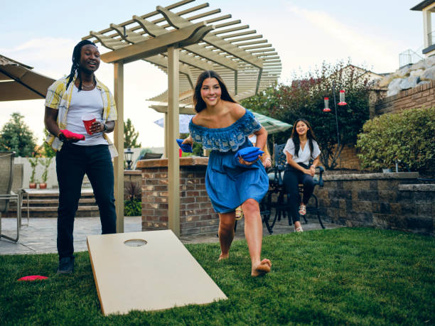 コーンホールビーンバッグトスゲームをプレイバックヤードパーティー - cornhole leisure games outdoors color image ストックフォトと画像