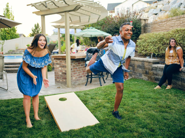 backyard party jouer au jeu de lancer de sac de haricots cornhole - cornhole leisure games outdoors color image photos et images de collection