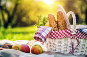 Picnic basket in the park at sunset