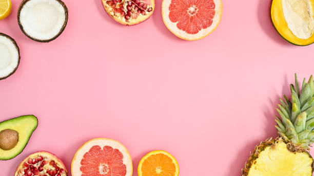 istock Summer tropic frame made with exotic fruits on pastel pink background. Flat lay. 1415245536