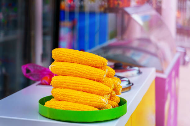 Peeled corn cobs are on the counter for cooking