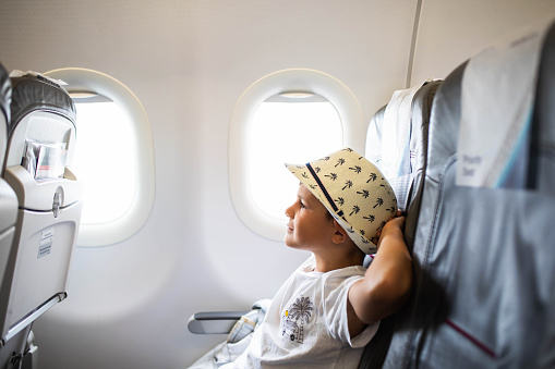 A cute young boy is relaxed on a flight