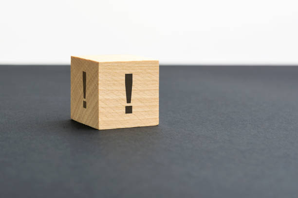 istock exclamation mark sign on a wooden block on a black background with copy space 1415247909