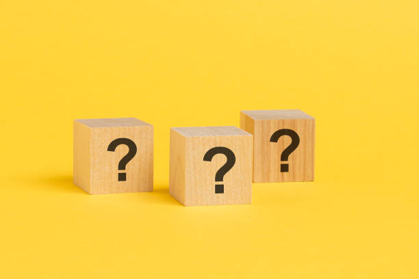 istock three cubes with question mark on wooden background. space for text, yellow background 1415247916
