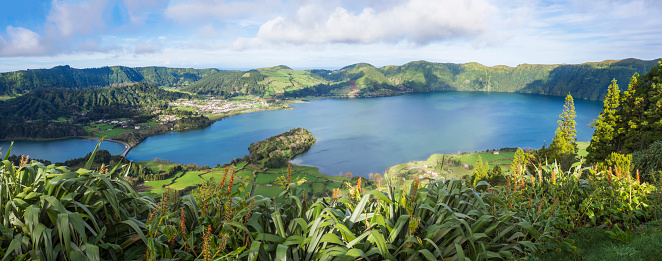 Panoramic landscape view of both green and blue crater lakes of Lagoa Azul and Lagoa Verde and Sete Cidades village in the crater of dormant volcanoes, on Sao Miguel island, Azores, Portugal.