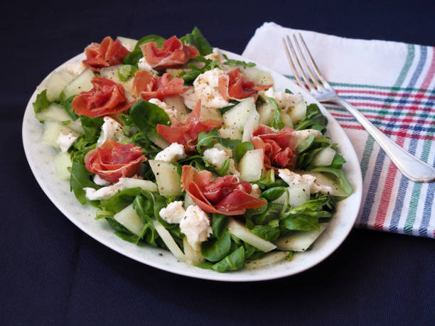 istock Salad with jamon serrano and melon in an oval plate. 1415249916
