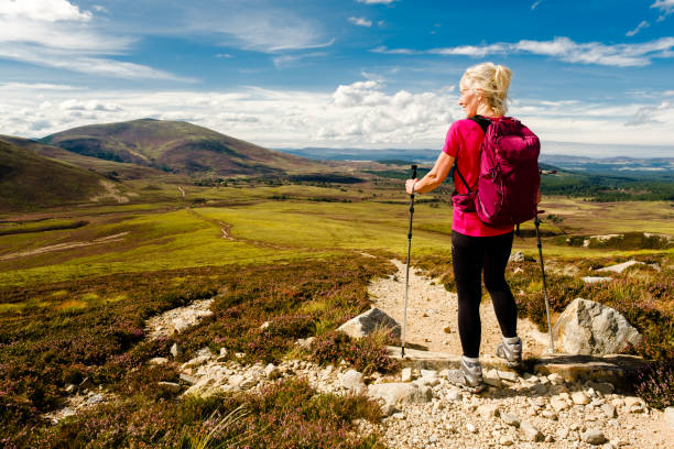 Looking North, Cairngorms, Scotland Woman stopping to admire the view on the trail ascending a mountain called Bynack More, beside Strath Nethy, in the Cairngorms National Park, Scotland. cairngorm mountains stock pictures, royalty-free photos & images