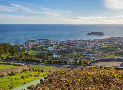 Aerial view of Vila Franca do Campo town with its famous volcanic islet near the coast, from viewpoint Miradouro da Senhora da Paz, golden hour, Sao Miguel island of Azores, Portugal.