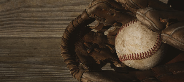 baseball ball and old dirty leather glove, top view