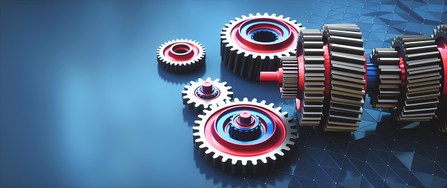 Shiny multi-colored abstract gear mechanism on a dark blue surface with ample copy space for composition.