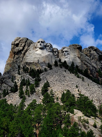 Majestic figures of George Washington, Thomas Jefferson, Theodore Roosevelt and Abraham Lincoln, surrounded by the beauty of the Black Hills of South Dakota