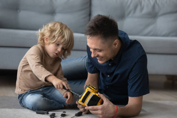 istock Happy little kid boy fixing toy with dad. 1415255228
