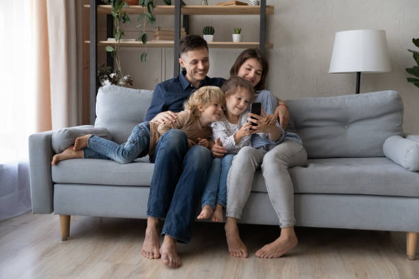 istock Relaxed carefree family using cellphone applications at home. 1415255266