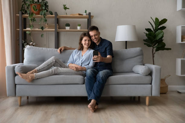 istock Relaxed happy young family couple using smartphone. 1415255913